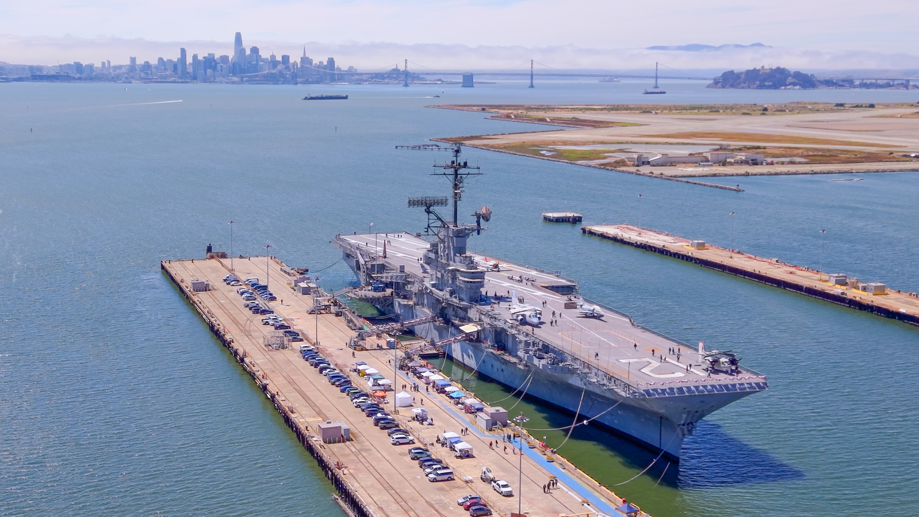 USS Hornet docked in Alameda, with San Francisco Bay and the city skyline beyond
